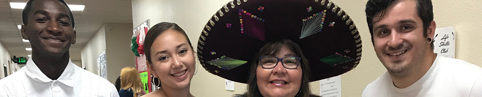 Four teachers smiling, one wearing a sombrero.